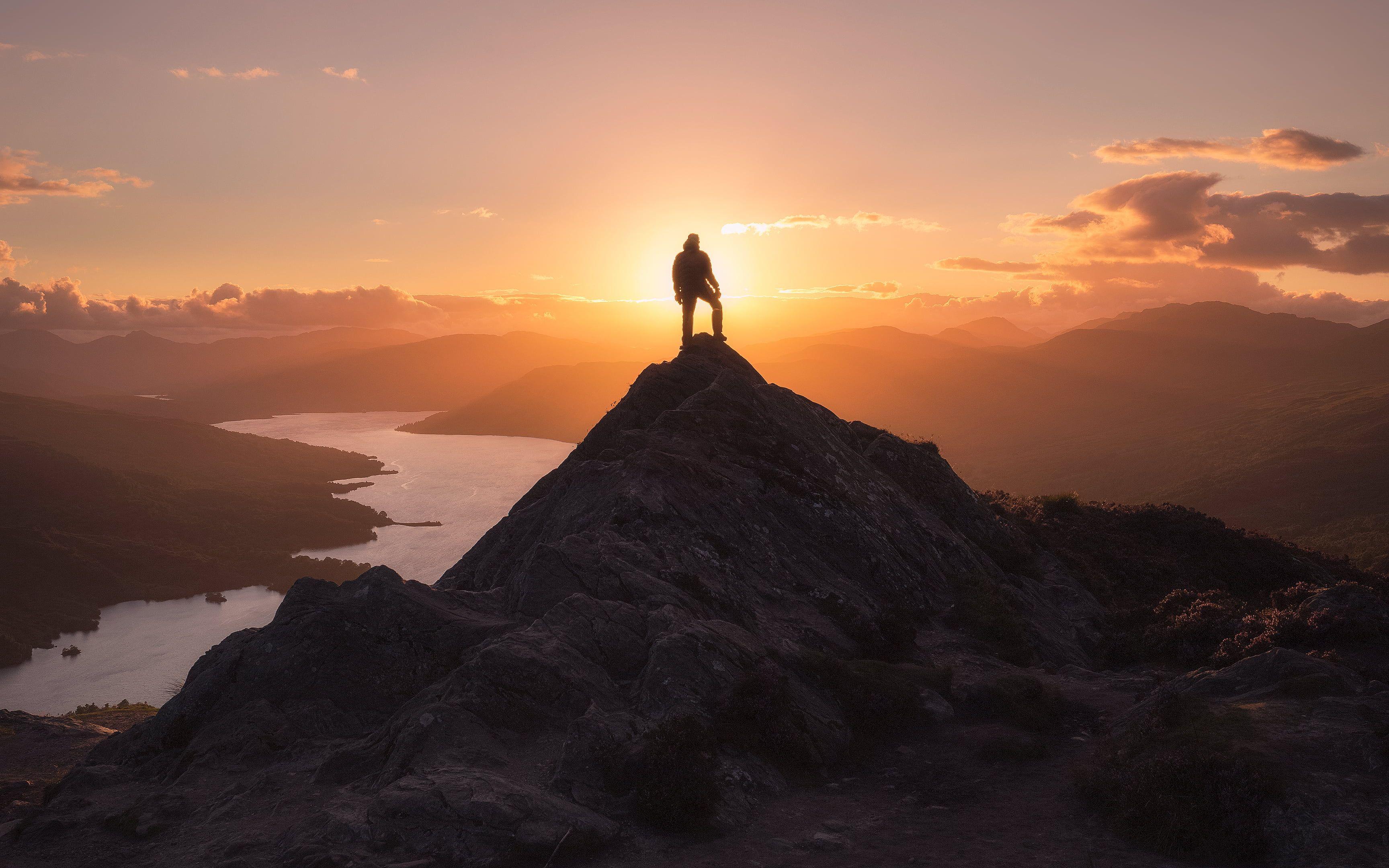Person standing on a mountain ridge looking out at the view